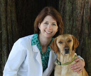 Dr. Erin Lane with dog in front of tree